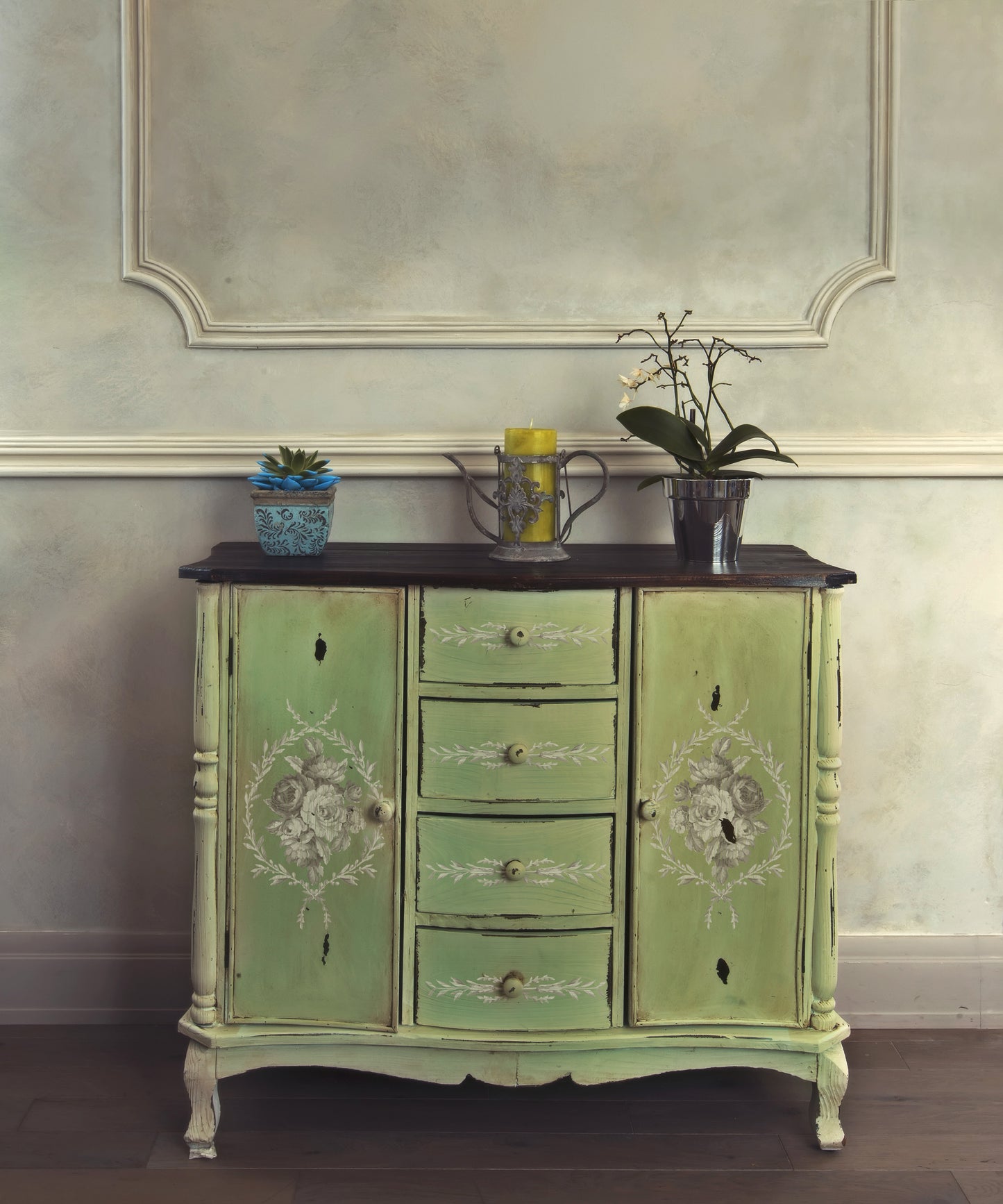 Iron Orchid Designs Tromp l'oeil Laurel Paint Inlay used on the front of a light green cupboard