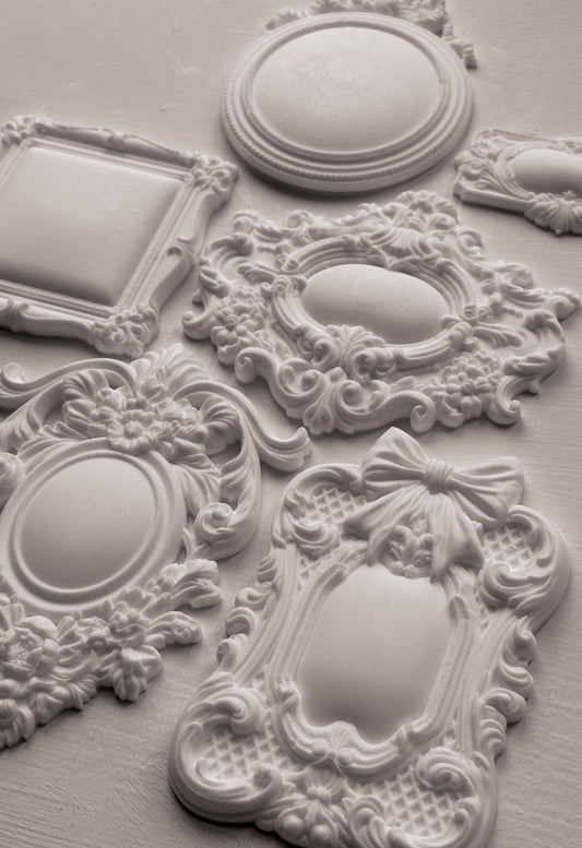 Decorative white clay castings with intricate designs on a light grey background from Iron Orchid Designs Frames 3 Mould