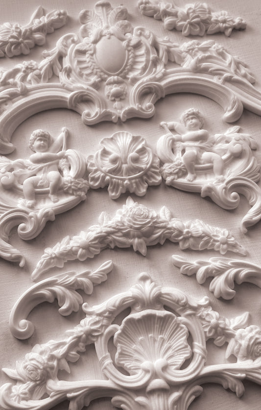 Close-up of ornate decorative stucco work with cherubs and shell designs from Iron Orchid Designs Cadre Mould