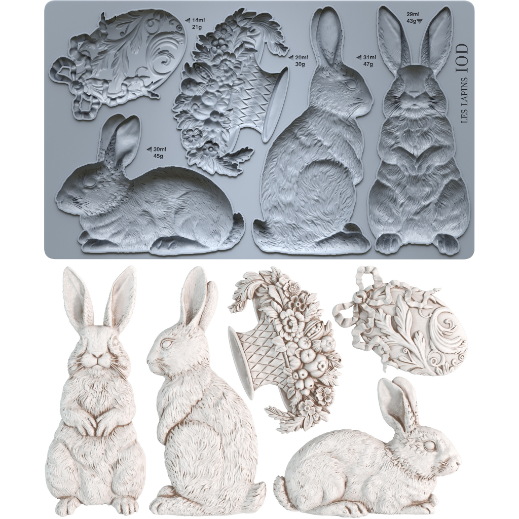 Grey silicone rabbit mould from Iron Orchid Designs above white castings from Les Lapins mould. All on a white background