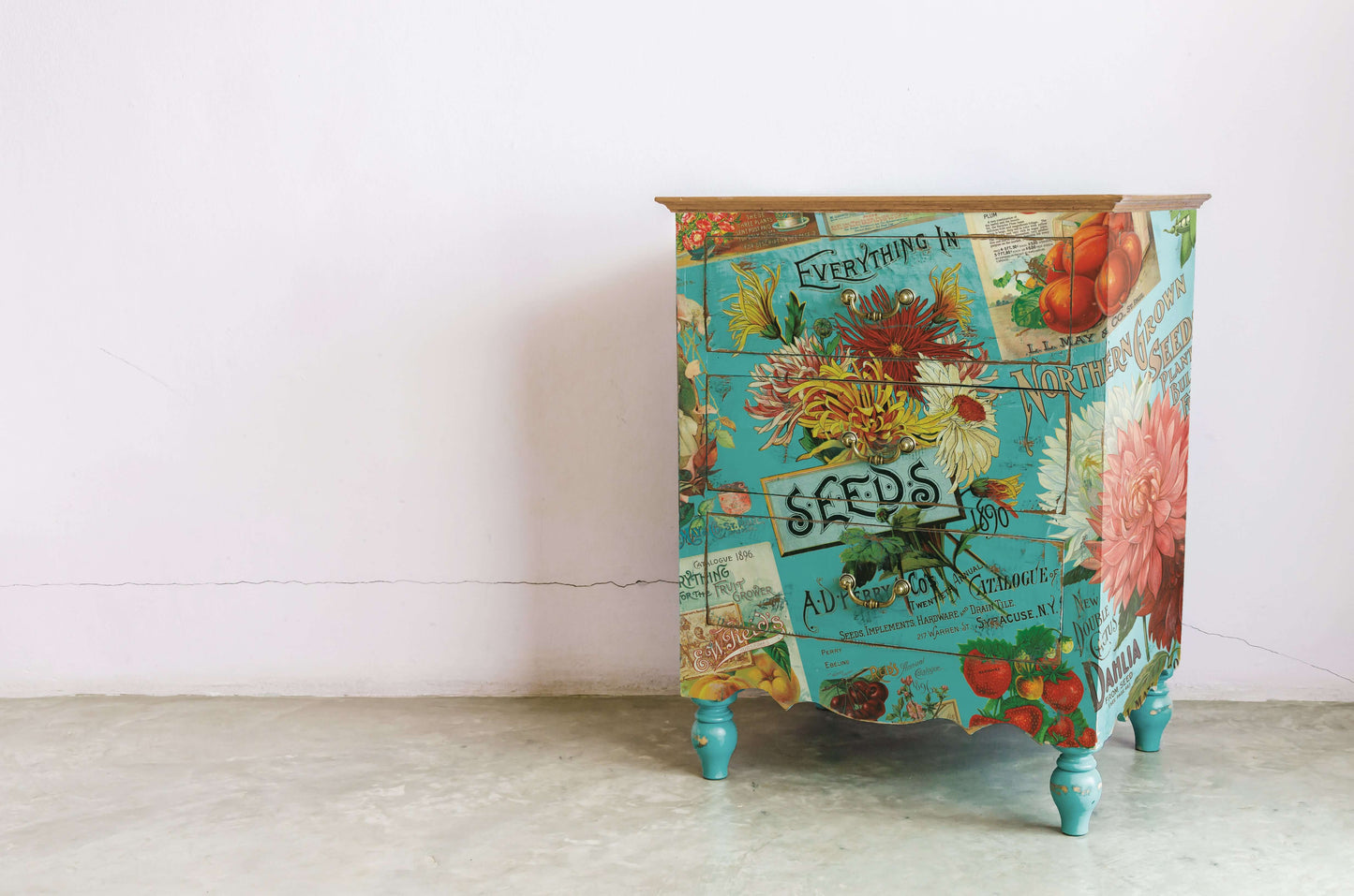 Small blue cupboard decorated with brightly coloured seed packets from Iron Orchid Designs Seed Catalogue Transfer