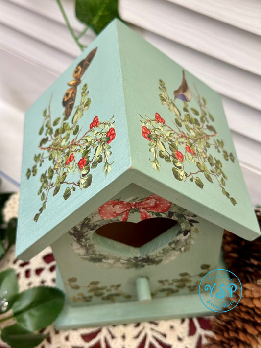Decorative birdhouse with floral designs on a white background