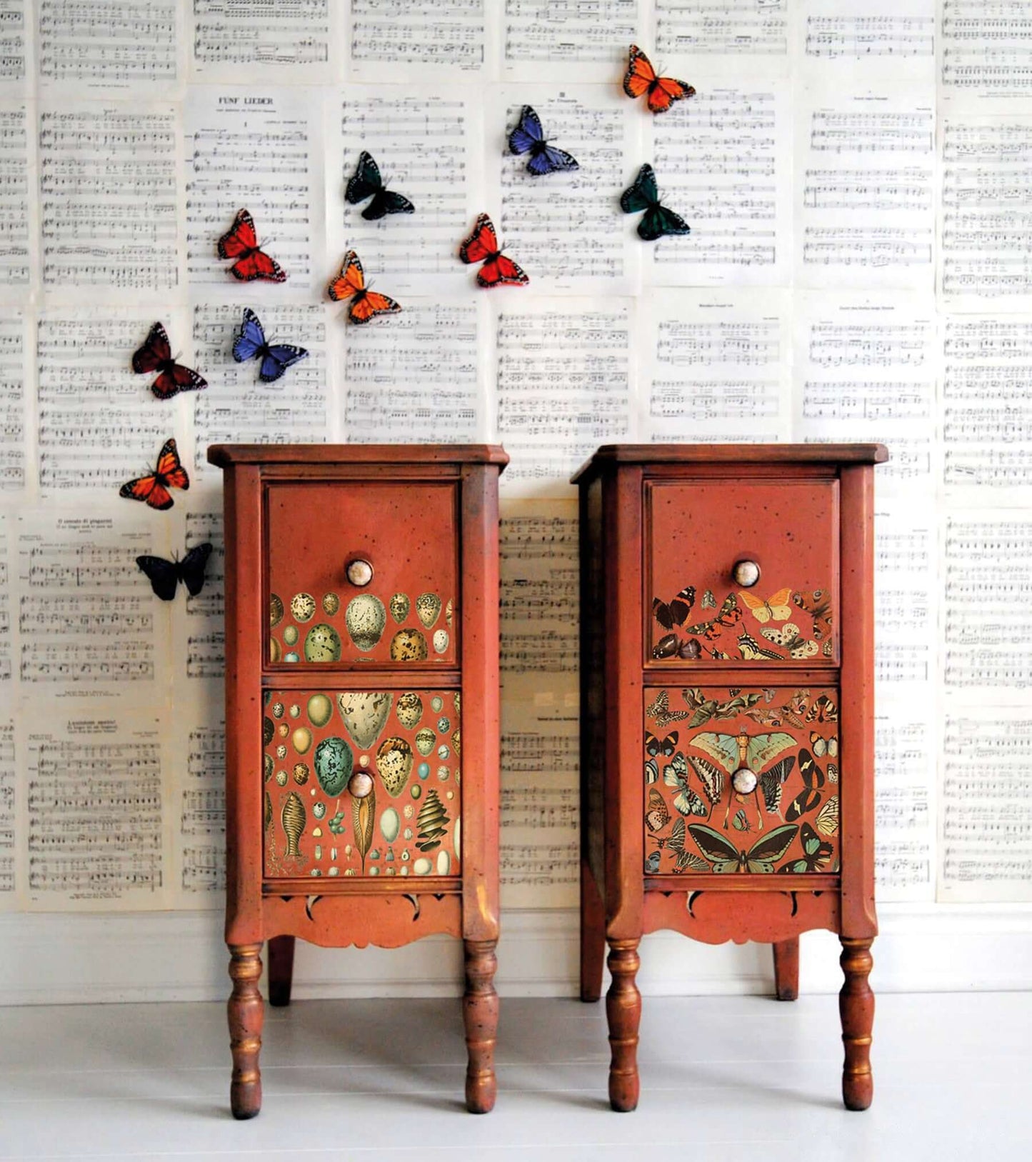 Iron Orchid Designs Millot's Pages Transfer on two small red chest of drawers standing side by side with a pale background.