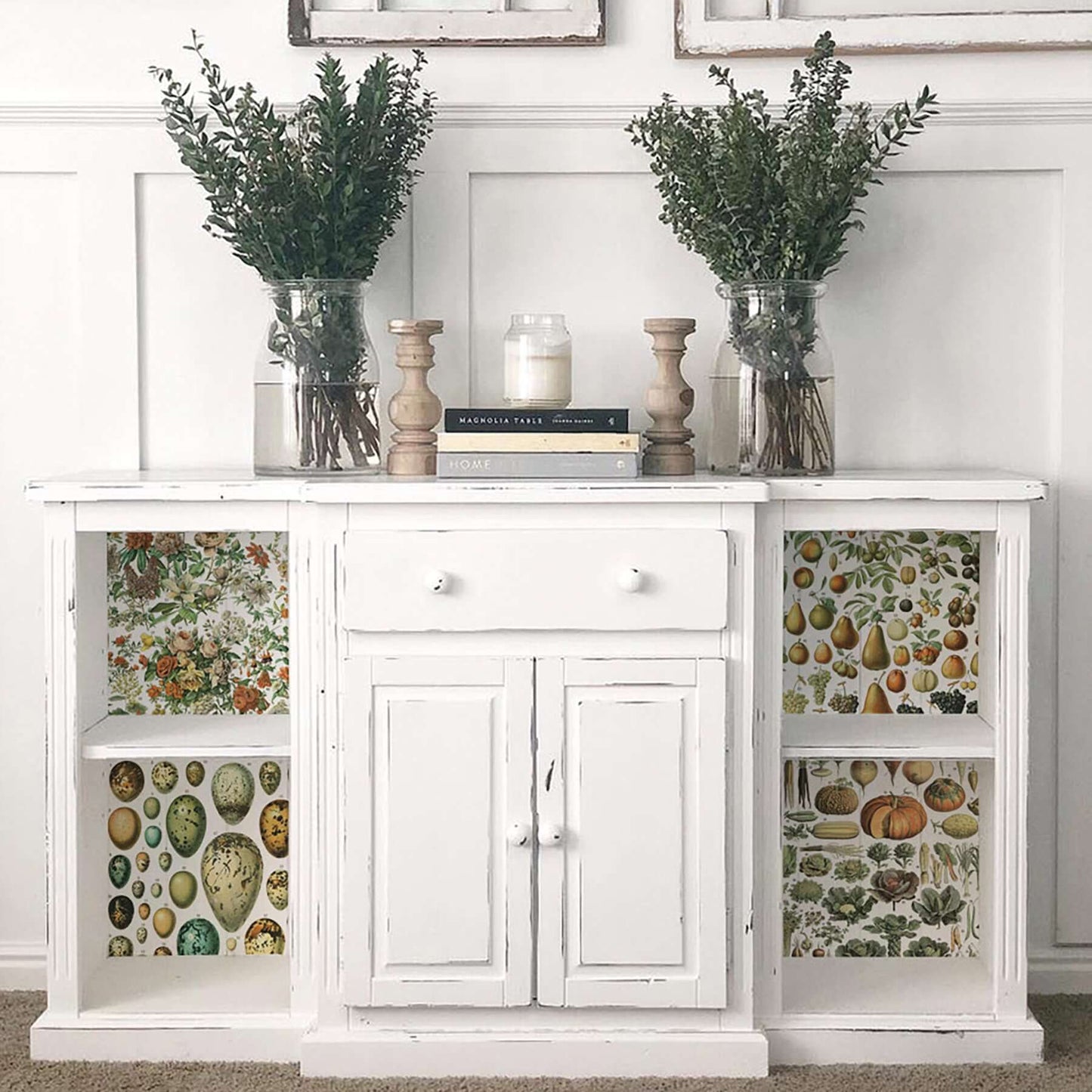 Iron Orchid Designs Millot's Pages Transfer applied to the end sections of a white cupboard with vases of flowers standing on top
