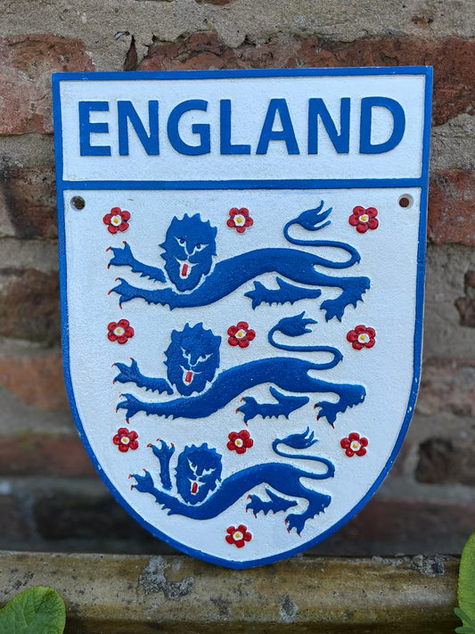 A shield shaped England sign with a white background, three blue lions and blue writing