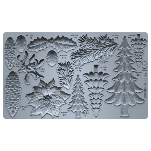 A gray silicone baking or craft mold tray with multiple embossed holiday botanical and tree shapes, including pinecones, holly leaves, mistletoe, and Christmas trees, each labeled with volume and weight measurements. Boughs of Holly Iron Orchid Designs