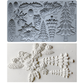 A mold tray with embossed Christmas tree, pinecone, holly, and floral shapes, shown above a white textured surface with the corresponding white embossed decorations. Boughs of Holly Iron Orchid Designs