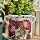Decorative white ceramic flower pot with floral design on a wooden surface
