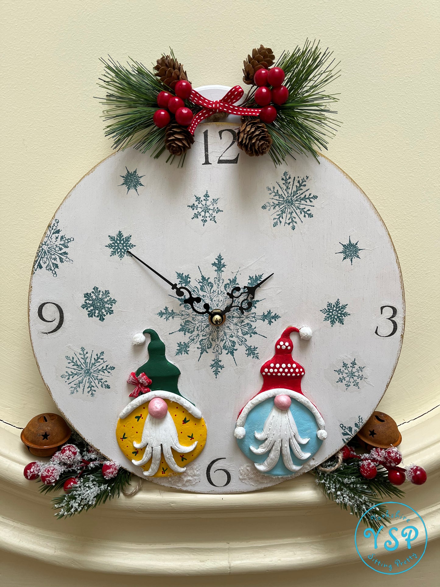 Hand painted round gnome clock featuring snowflakes on the face and two gnomes at the bottom created from Bibelots mould.
