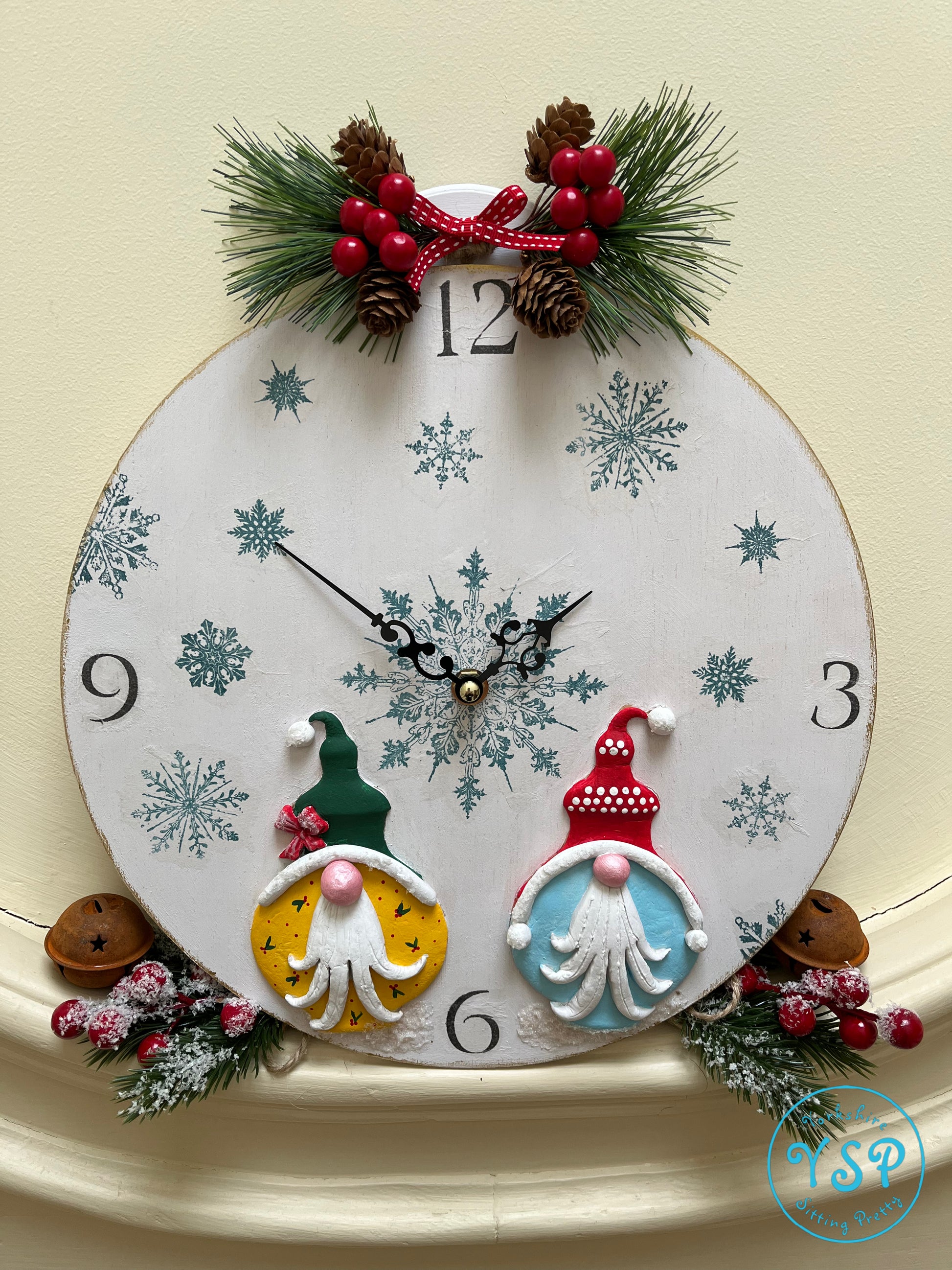 Hand painted round gnome clock featuring snowflakes on the face and two gnomes at the bottom created from Bibelots mould.
