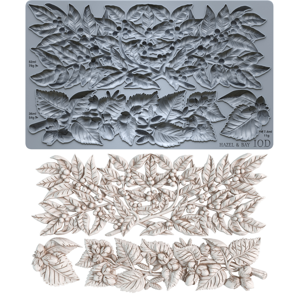 A gray silicone baking or craft mold sheet with embossed floral and leaf patterns, shown above a set of matching light beige carved floral and leaf pieces on a white background. Hazel and Bay. From Iron Orchid Designs.