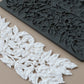 White air dry clay leaf and berry floral trim shown next to a dark gray silicone mold that creates the same leaf pattern, on a solid beige background. Hazel and Bay mould. From Iron Orchid Designs.