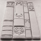 Decorative white bookends with intricate designs on a grey surface from Iron Orchid Designs Bookish mould