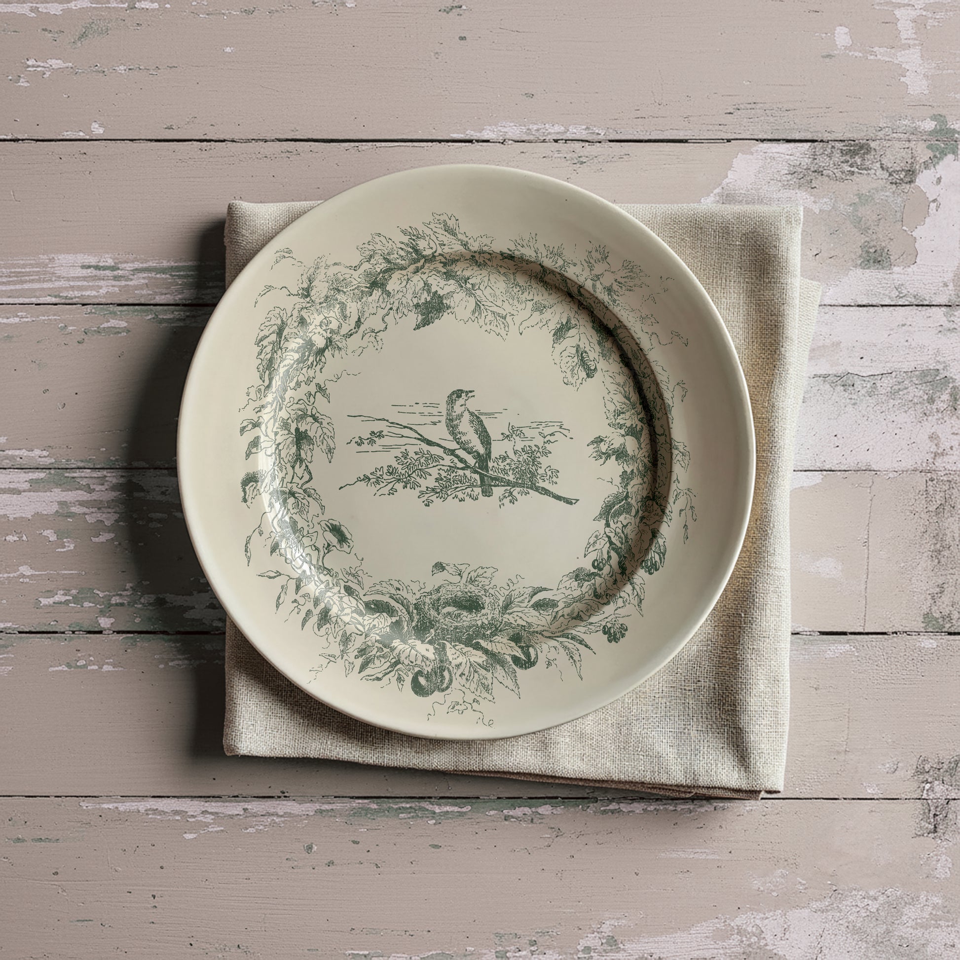 Decorative plate with bird and floral design in green on a textured surface