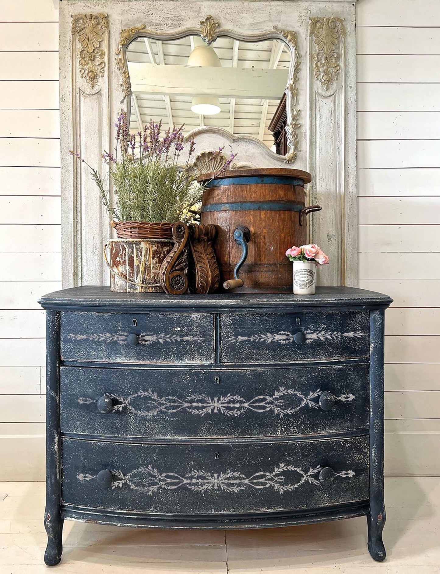 Iron Orchid Designs Tromp l'oeil Laurel Paint Inlay used on the front of a dark blue painted chest of drawers