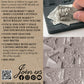 Back of a package for Iron Orchid Designs Jod Moulds, featuring product information, a barcode, social media links, and a photo of a hand pressing clay into a grey silicone mould. 