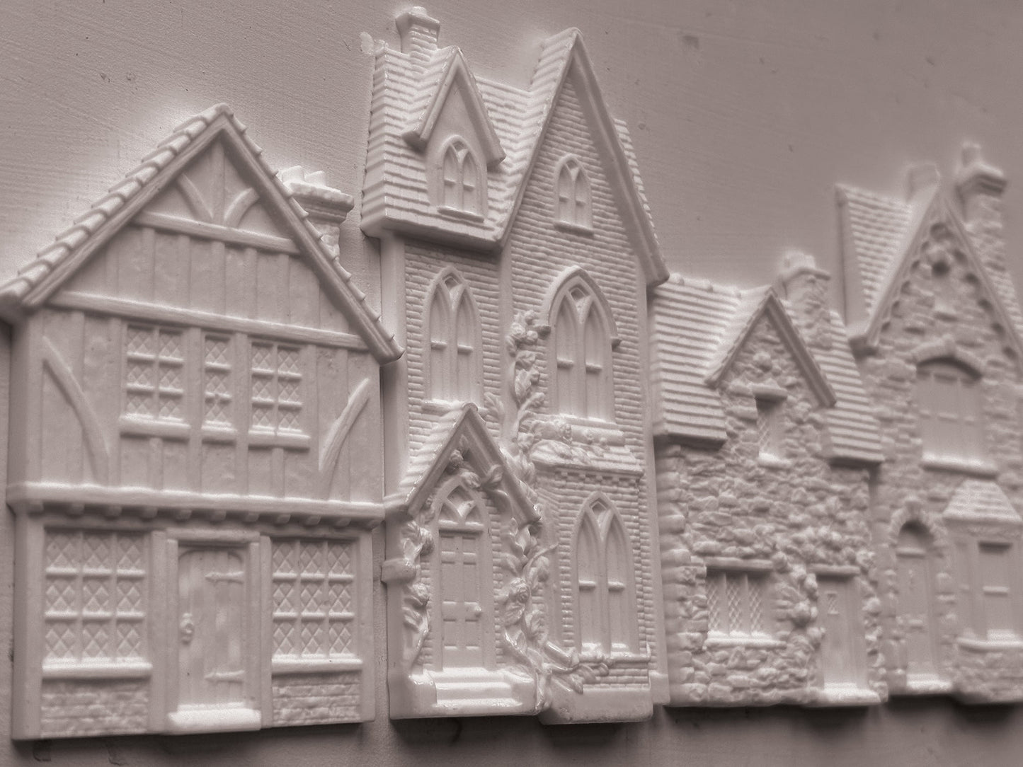White embossed resin decorative pieces shaped like houses and cottages, shown on a plain light background. Charlbury Lane mould From Iron Orchid Designs.