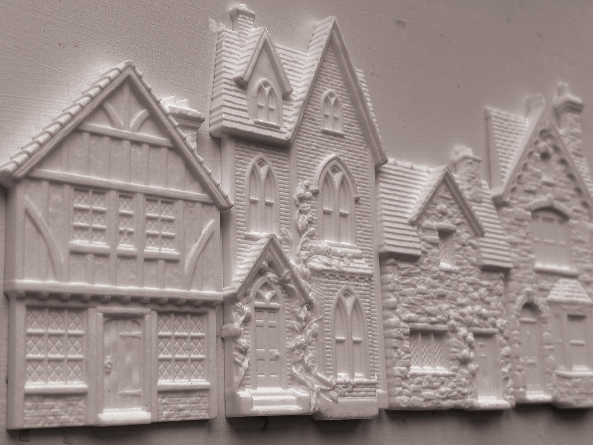 White embossed resin decorative pieces shaped like houses and cottages, shown on a plain light background. Charlbury Lane mould From Iron Orchid Designs.