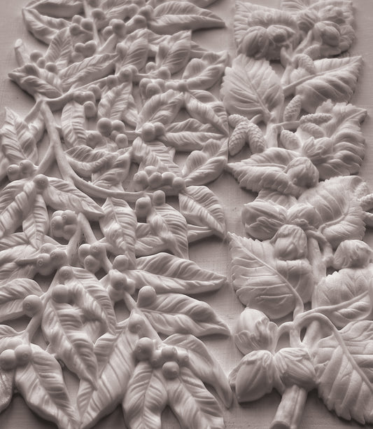 White carved floral and leaf wall panel with raised botanical relief details on a matching background. From Iron Orchid Designs.