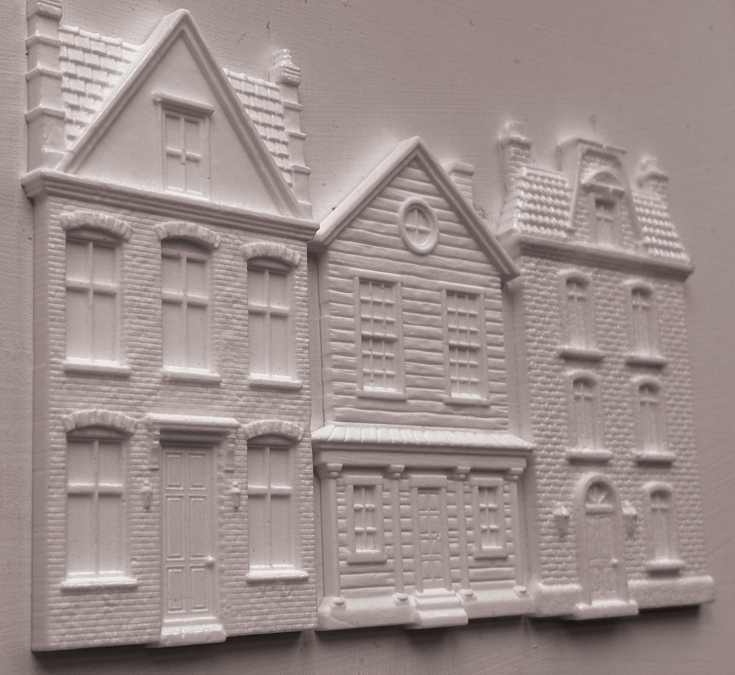 White clay miniature building pieces for dioramas, featuring detailed house designs with windows, doors, and textured brick patterns, arranged on a light gray background. Old Colchester Road Mould From Iron Orchid Designs.