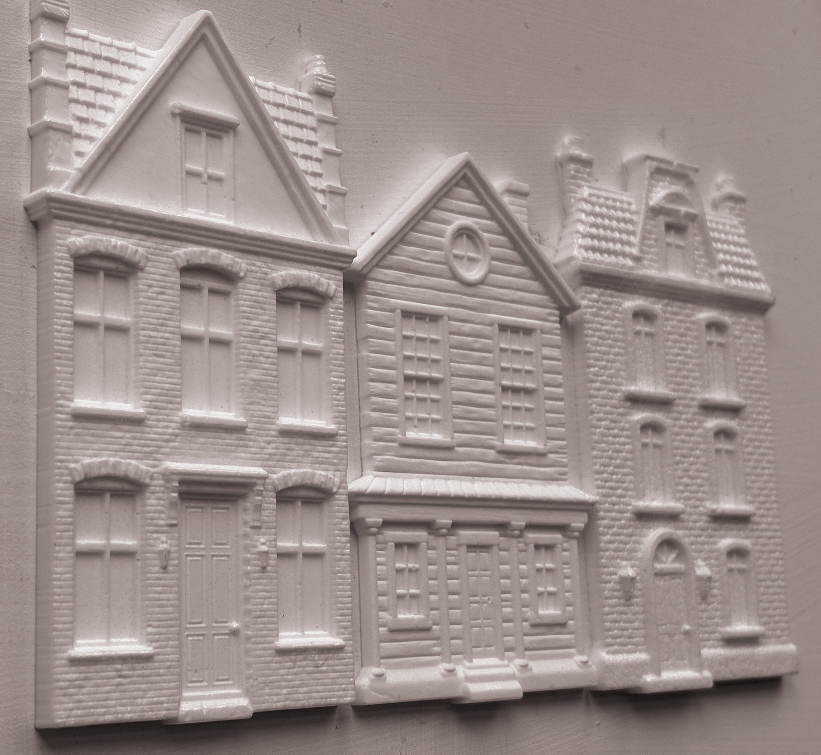 White clay miniature building pieces for dioramas, featuring detailed house designs with windows, doors, and textured brick patterns, arranged on a light gray background. Old Colchester Road Mould From Iron Orchid Designs.