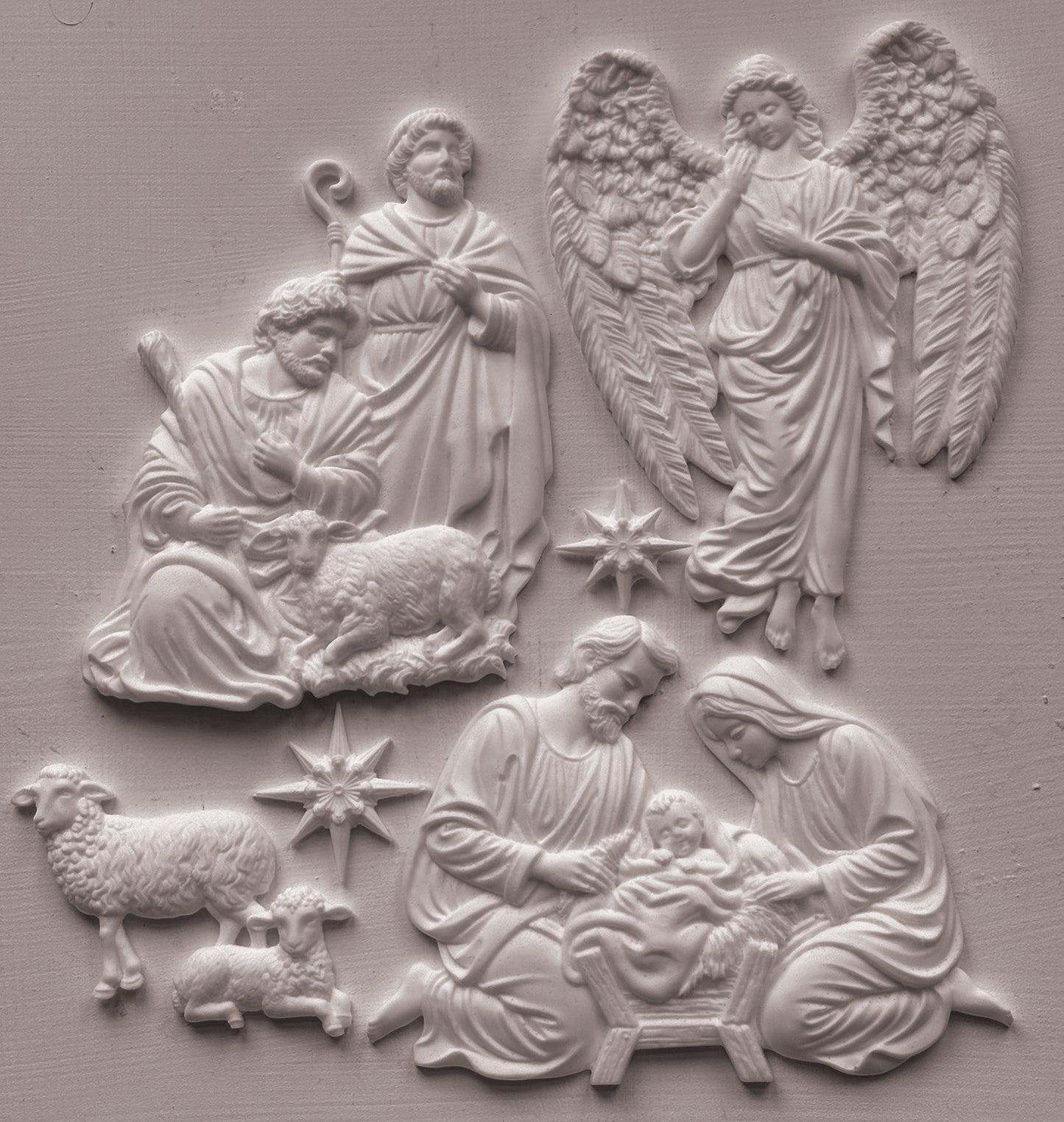 White clay castings depicting the Holy Family, angels, and sheep on a textured light gray background. Silent Night mould from Iron Orchid Designs.