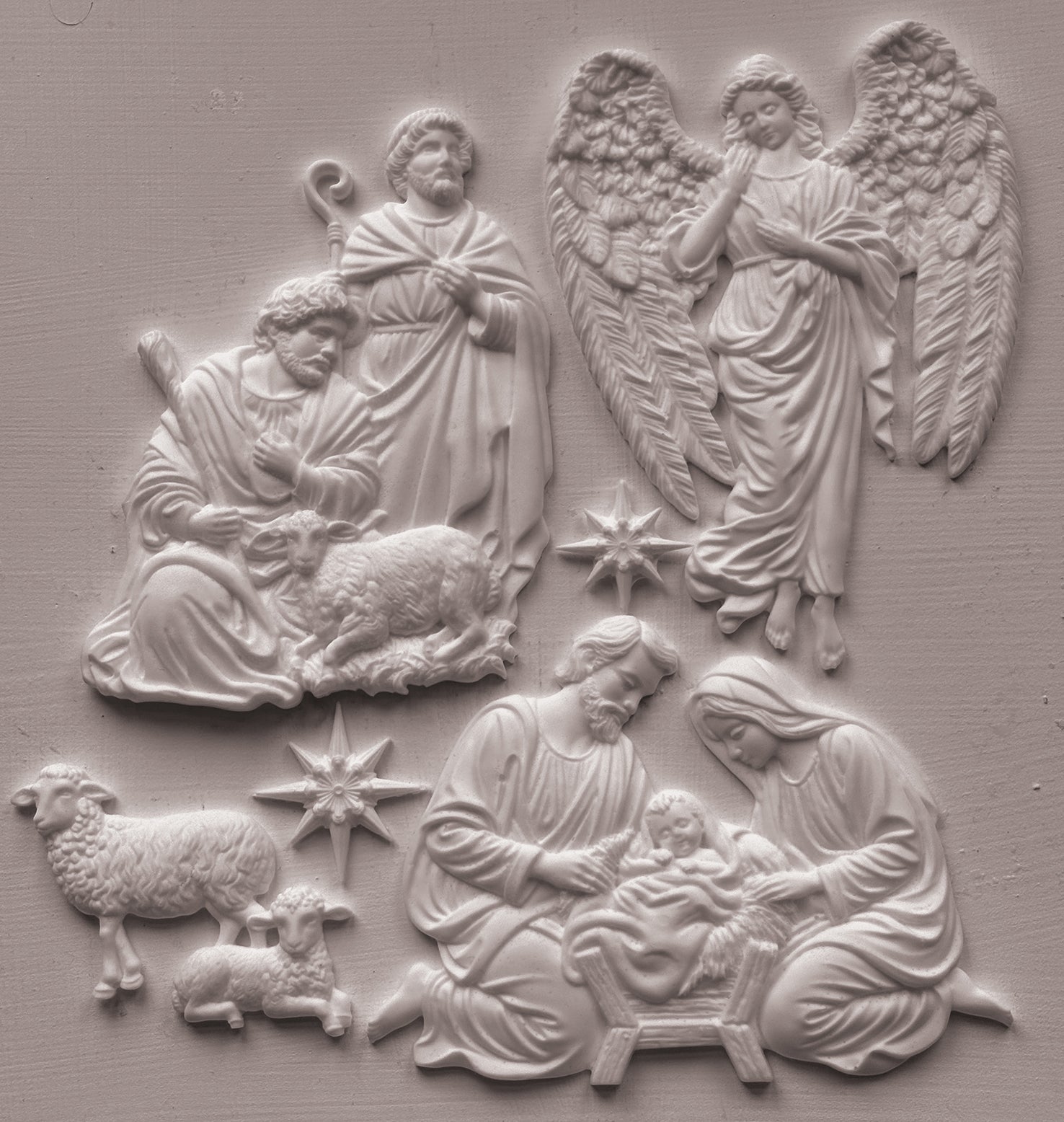 White clay castings depicting the Holy Family, angels, and sheep on a textured light gray background. Silent Night mould from Iron Orchid Designs.