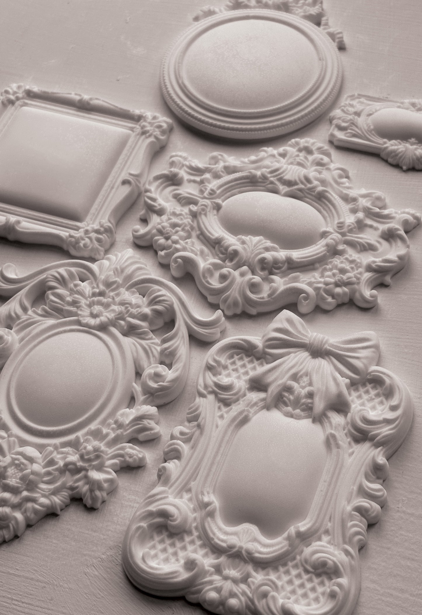 Decorative white clay castings with intricate designs on a light grey background from Iron Orchid Designs Frames 3 Mould