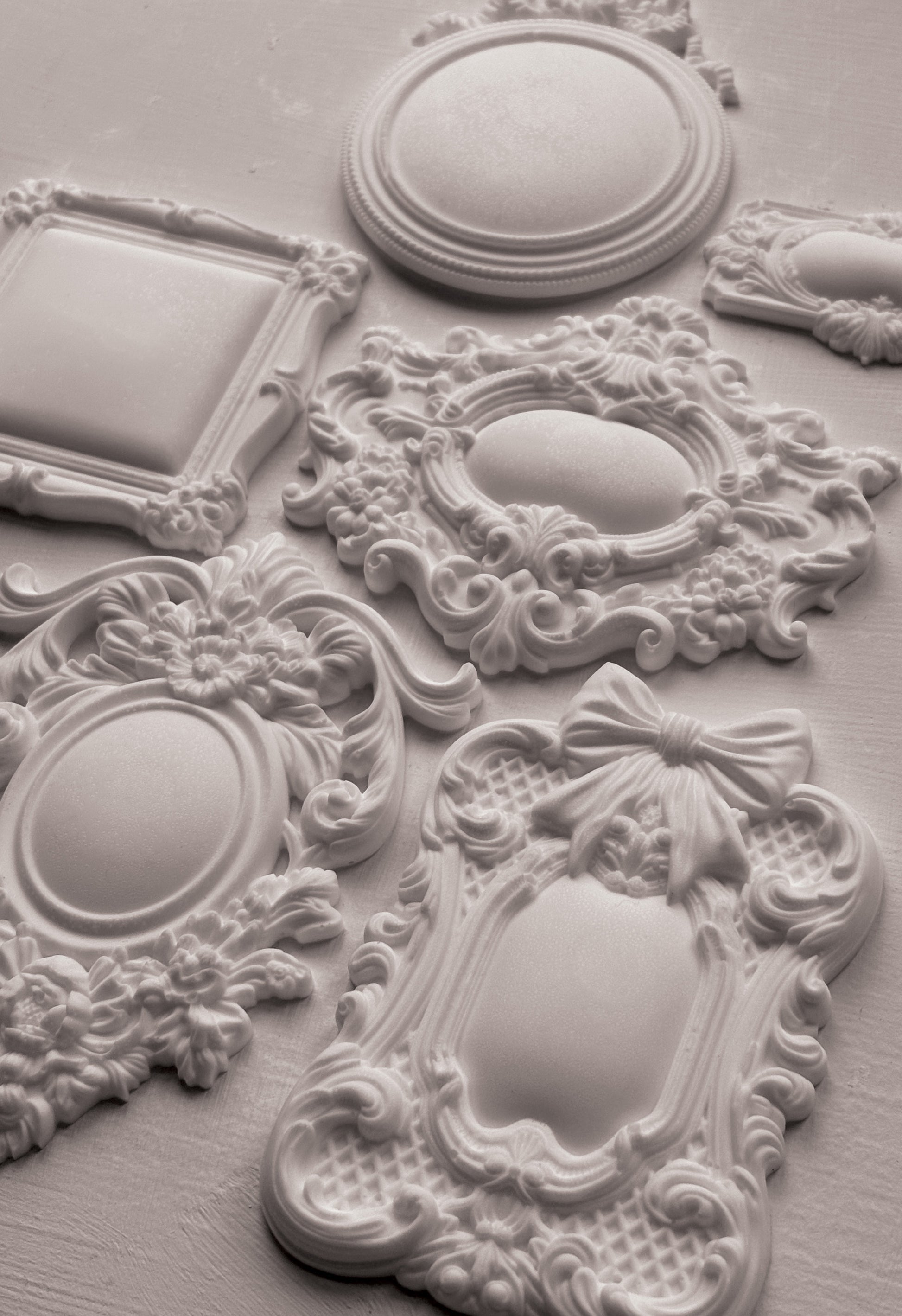 Decorative white clay castings with intricate designs on a light grey background from Iron Orchid Designs Frames 3 Mould