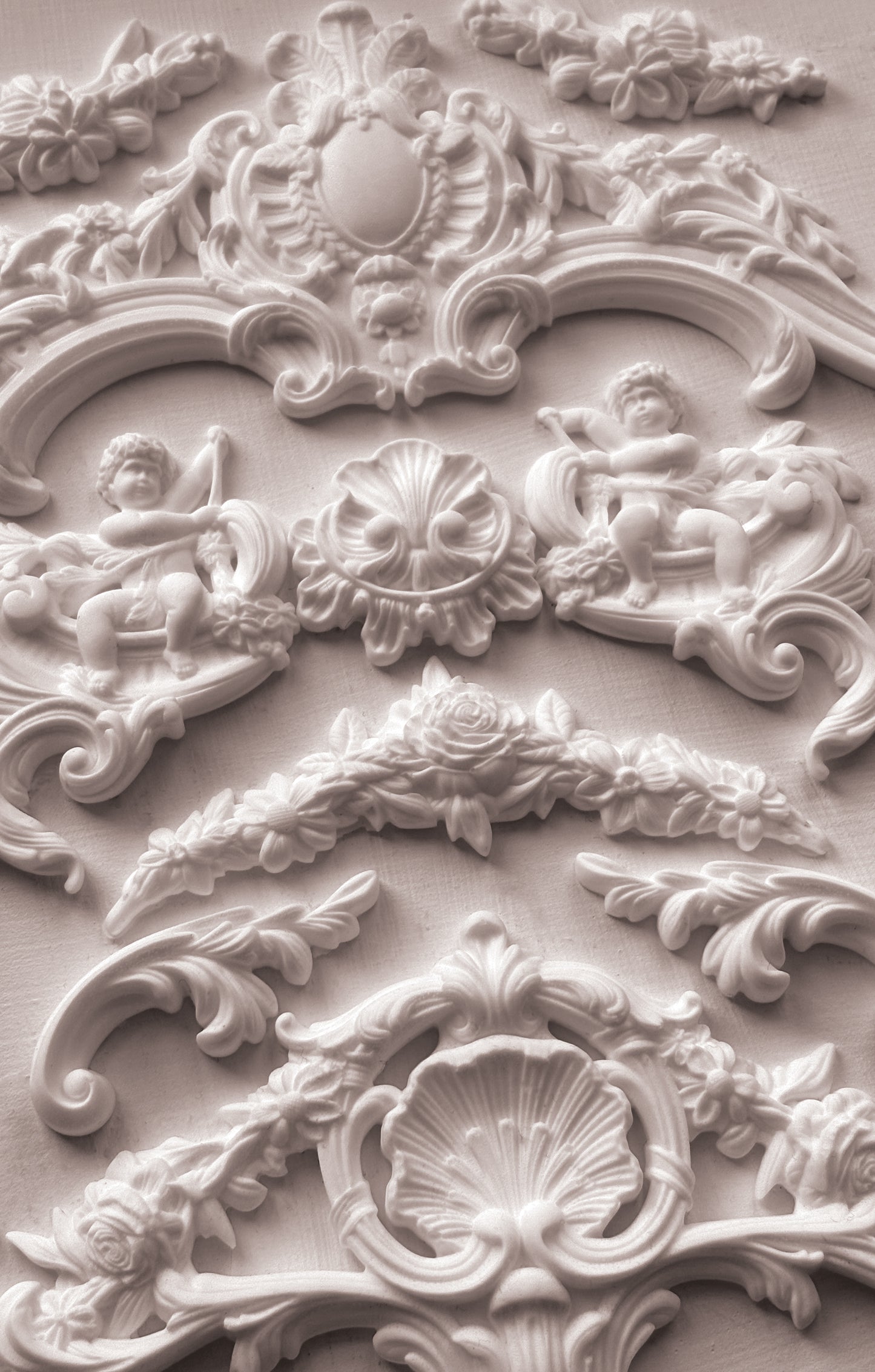 Close-up of ornate decorative stucco work with cherubs and shell designs from Iron Orchid Designs Cadre Mould