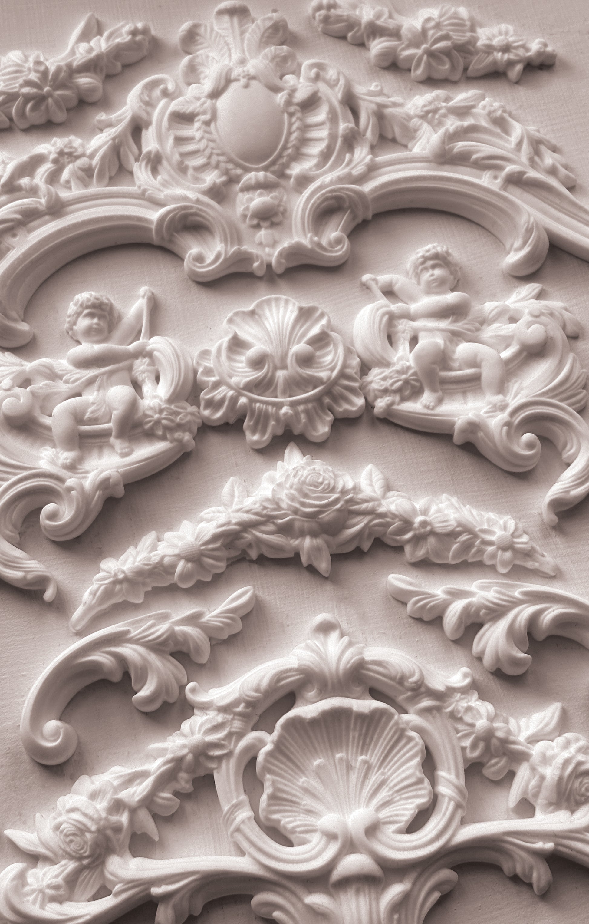 Close-up of ornate decorative stucco work with cherubs and shell designs from Iron Orchid Designs Cadre Mould