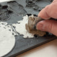 Person using a tool to remove excess material  from Iron Orchid Designs Frames 3 Mould