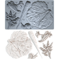 Grey silicone Spring Garden vegetable mould by Iron Orchid Designs above white clay castings from the same mould. Both on a white background