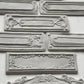 White clay castings of Iron Orchid Designs Conservatory Labels castings laid on top of a white surface
