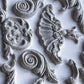 A close up of white castings from Iron Orchid Designs Dainty Flourishes mould. The castings are on a white background