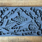 Iron Orchid Designs Dainty Flourishes grey Mould laying on a wooden surface