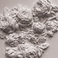 A close up image of white castings from Iron Orchid Designs Felicite mould. The flowers have been arranged into a cluster and are on a white background.