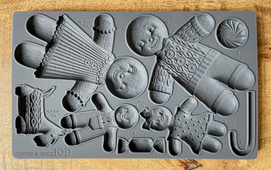 A grey-coloured decor mould by Iron Orchid Designs featuring gingerbread figures and holiday-themed patterns.