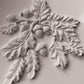 A close up images of white clay castings from Iron Orchid Designs Oak leaves and Acorns mould. The white castings are on a white background