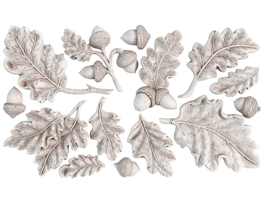 White castings from Iron Orchid Designs Oak Leaves an Acorns mould. The images shows a collection of acorns and leaves on a white background