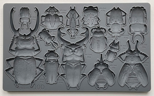 A grey silicone mould from Iron Orchid Designs featuring various insect shapes, such as beetles and bugs for crafting and baking purposes.