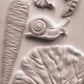 Close up of white castings from Iron Orchid Designs Spring Garden Mould on a white background
