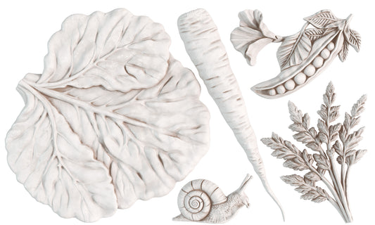 White clay castings of a cabbage leaf, pea pod, a carrot, carrot tops and a snail on a white background from Iron Orchid Designs Spring Garden mould