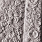 A close up photograph of the beautiful intricately designed flowers from Iron Orchid Designs Trimmings 4 mould. The flowers are white clay