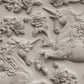 White clay castings of Iron Orchid Designs Unicorns and flowers on a white background