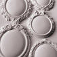 White clay castings from Iron Orchid Designs Vintage Brooches mould. he image is of five castings on a white background