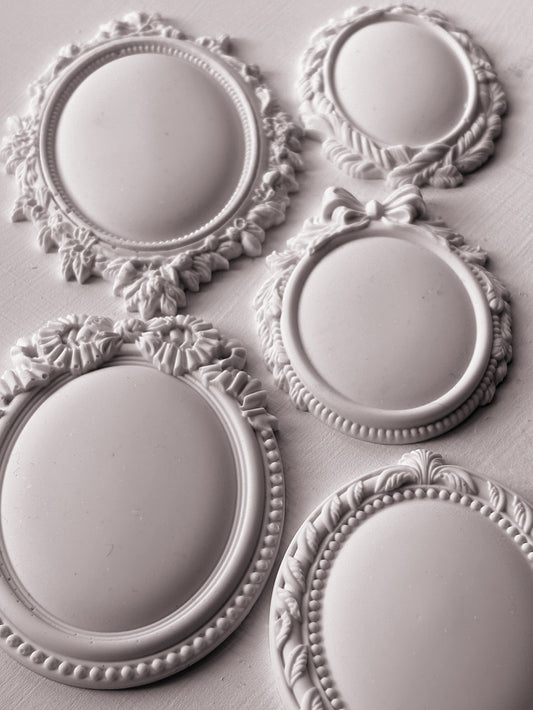 White clay castings from Iron Orchid Designs Vintage Brooches mould. he image is of five castings on a white background