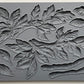 A gray silicone craft mould from iron Orchid Designs featuring a design of leaves and branches.