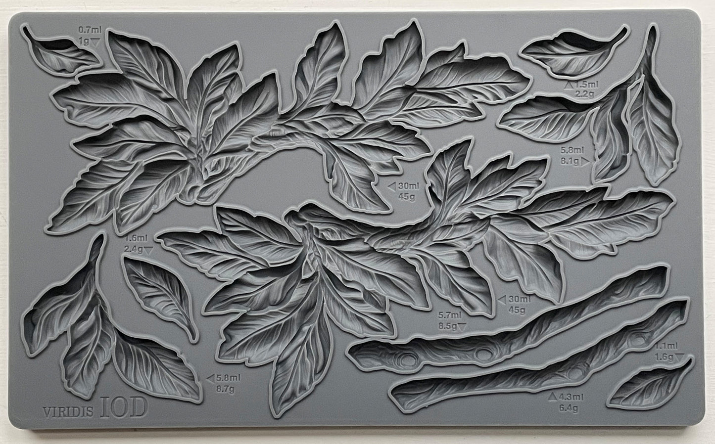 A gray silicone craft mould from iron Orchid Designs featuring a design of leaves and branches.