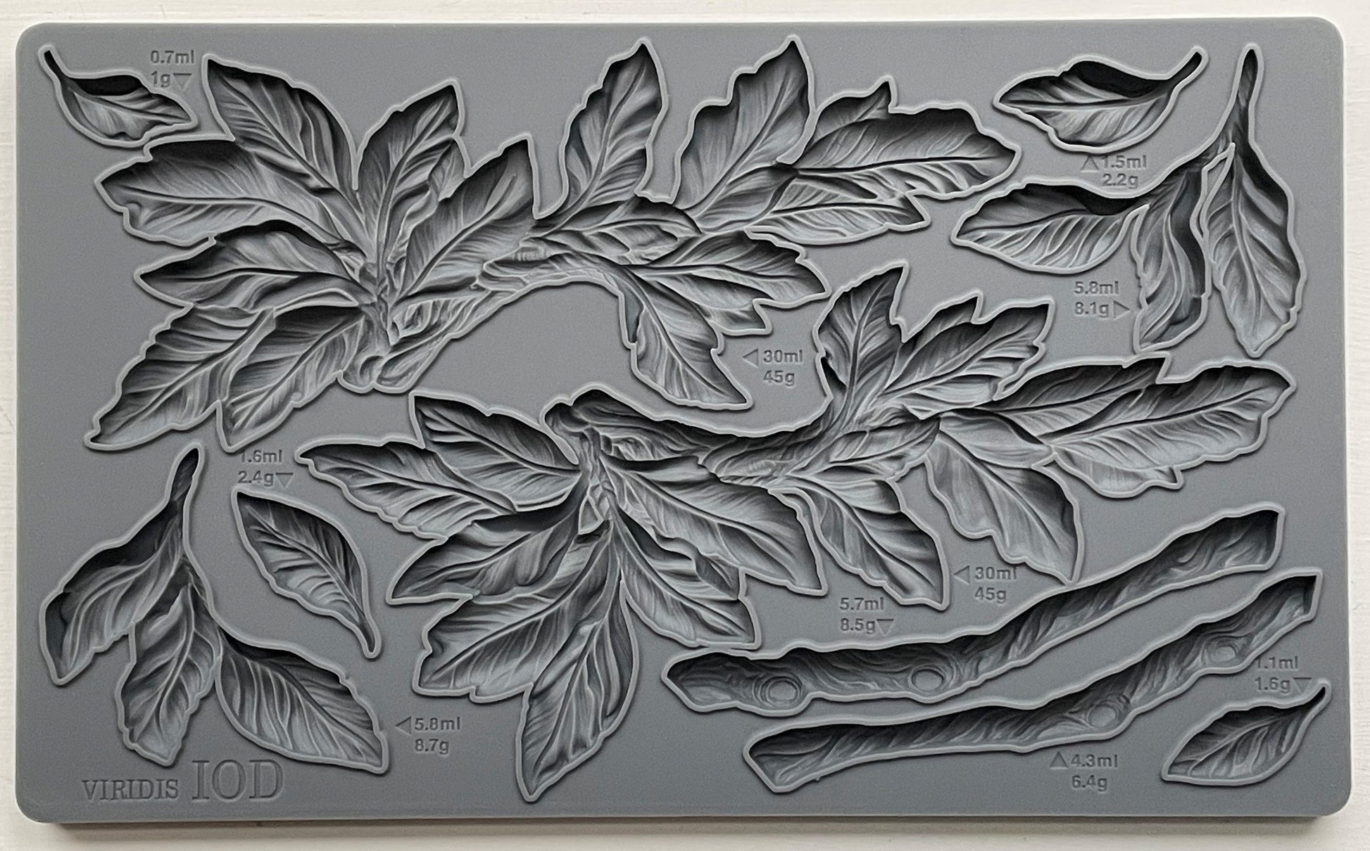 A gray silicone craft mould from iron Orchid Designs featuring a design of leaves and branches.